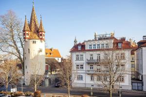a building with a clock tower in a city at Comic Fantasy in Lindau