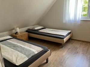 two beds in a small room with a window at Kehl Vogt Ferien Apart in Warstein