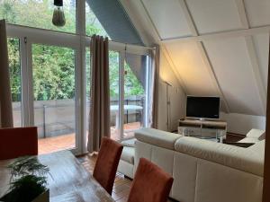 a living room with a couch and a table and a television at Kehl Vogt Ferien Apart in Warstein