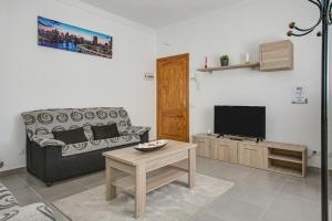 a living room with a couch and a tv at 2a Francesca in Vecindario