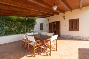 a dining room with a wooden table and chairs at Villa Zagara in Partinico