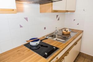 a kitchen counter with a sink and a stove at Ferienwohnung Lanz 3 in Lana