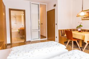 a bedroom with a bed and a table and a bathroom at Ferienwohnung Lanz 3 in Lana