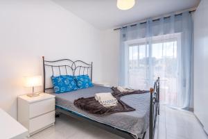 a bedroom with a bed with blue pillows and a window at Isabel apartment in Carvoeiro