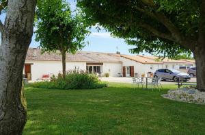 a house with a table and chairs in a yard at Studio à La Ferme in Sémussac