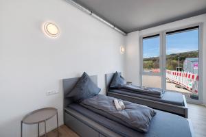 ein Zimmer mit zwei Betten, einem Tisch und einem Fenster in der Unterkunft Boardinghouse27 in Dußlingen