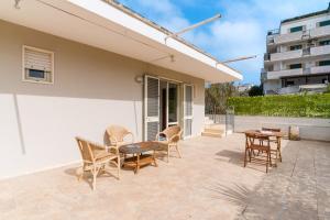 a patio with chairs and a table and a building at Andromeda's Rooms in Otranto