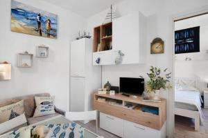 a living room with a couch and a tv on a desk at Casa di Ali in Imperia