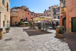 a courtyard with tables and umbrellas on a city street at Casa di Ali in Imperia