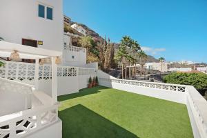 a white house with a balcony with green grass at Casa Sol 21 B Garachico in Garachico