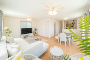 a living room with a white couch and a table at 照間Terumaの美しい海Mareまで徒歩30秒リビング広々快適 TERUMAREテルマーレ in Uruma