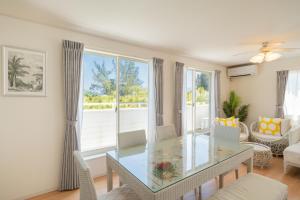 a living room with a glass table and chairs at 照間Terumaの美しい海Mareまで徒歩30秒リビング広々快適 TERUMAREテルマーレ in Uruma