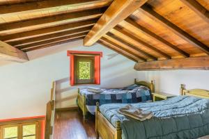 two beds in a room with wooden ceilings at Il Serrino 5 in Pistoia