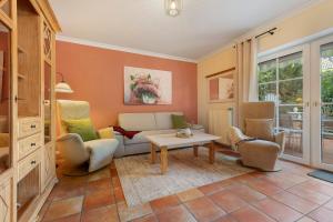 a living room with a couch and chairs and a table at Ferienhaus Jadeblick I I in Dangast
