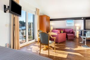 a hotel room with a bedroom with a living room at Haus Ostseesonne in Baabe