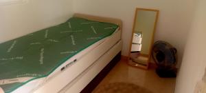 Ein Bett mit einer grünen Bettdecke neben einem Spiegel in der Unterkunft Brač Milna in Milna