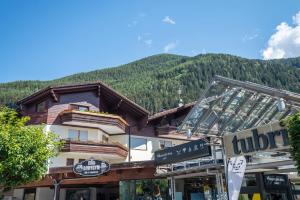 a large building with a mountain in the background at Tubris Living in Sand in Taufers