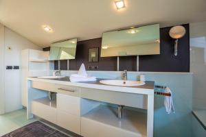 a bathroom with two sinks and a mirror at Tubris Living in Sand in Taufers +27 photos