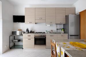 a kitchen with wooden cabinets and a stainless steel refrigerator at Da Ercolino in Pitelli +12 photos