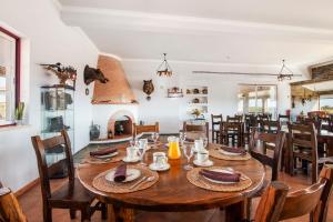 a dining room with a wooden table and chairs at Casas do Monte in Giões