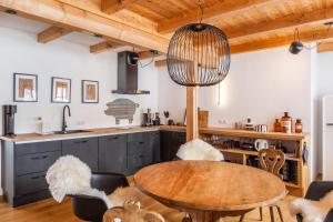 a kitchen with a wooden table and a dining room at Chalet Flocke Appart Murmeltier in Sankt Anton am Arlberg