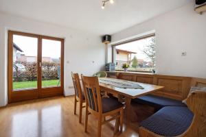 a dining room with a table and chairs and windows at Ferienhaus Hilde in Schwangau