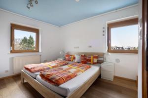 a bedroom with a large bed and two windows at Ferienhaus Hilde in Schwangau