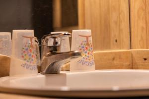 a bathroom sink with a faucet and four cups at Anna-purna in Arâches-la-Frasse +19 photos