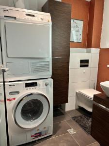 a washing machine with a tv on top of it in a bathroom at Ferienhaus Frank Grieser in Hopferau