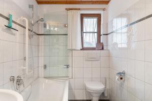 a white bathroom with a toilet and a sink at Haus Verdandi in Sibratsgfäll +17 photos