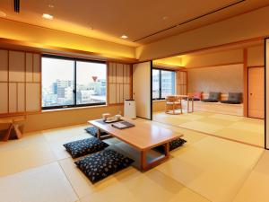 a living room with a table and some windows at Kyoto Hot Spring Hatoya Zuihokaku Hotel in Kyoto