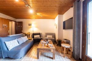a living room with a blue couch and a table at Chalet Le Grand Nant in La Giettaz