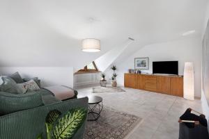 a living room with a green couch and a tv at Fewo Worb in Rielasingen-Worblingen