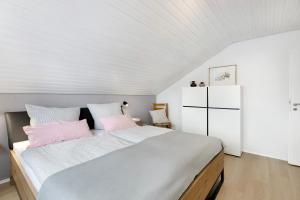 a bedroom with a large bed with pink pillows at Fewo Worb in Rielasingen-Worblingen