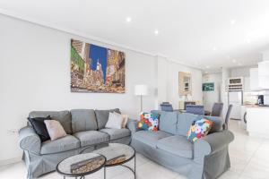 a living room with a gray couch and tables at Casa del Sol Premium Cabo Roig in Orihuela