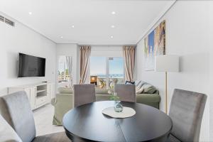 a living room with a table and chairs at Casa del Sol Premium Cabo Roig in Orihuela
