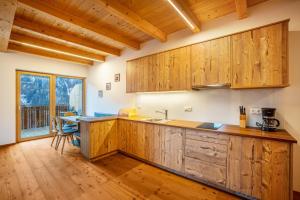 a kitchen with wooden cabinets and a wooden floor at Kreuzplonhof Apt Dorfblick in Luson +20 photos