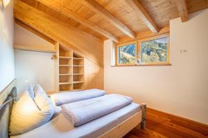a bedroom in a tiny house with a window at Kreuzplonhof Apt Dorfblick in Luson