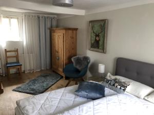 a living room with a bed and a chair at Logierhaus An der Truse in Brotterode