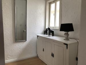 a lamp on a cabinet in a room with a window at Logierhaus An der Truse in Brotterode +16 photos