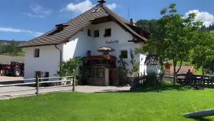 a white house with a fence and a yard at Ronacherhof Apt Ringelblume in Collalbo