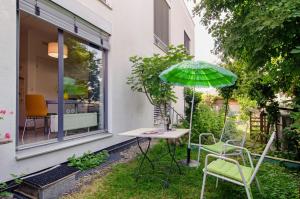 a patio with a table and chairs and an umbrella at Studio-in der atelierhaus Loft in Bodman-Ludwigshafen