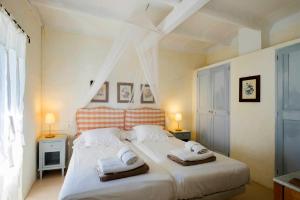 a bedroom with a large white bed with two towels at Baix d' Or in Felanitx