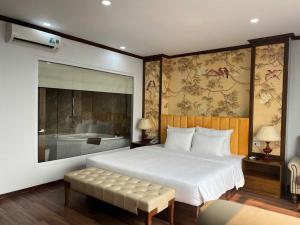 a bedroom with a large white bed and a bench at Hanoi Central Westlake Hotel in Hanoi