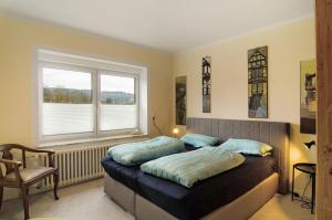 a bedroom with a bed and a chair and a window at Haus unterm Räuschenberg in Höxter