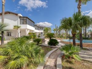 a white house with palm trees and a swimming pool at Villa Bludea - Salento in Torre Lapillo