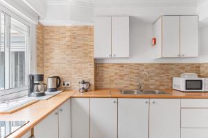 a white kitchen with white cabinets and a sink at Calle Apolo 3 in Torrevieja +14 photos