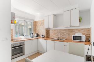 a white kitchen with white cabinets and a microwave at Calle Apolo 3 in Torrevieja