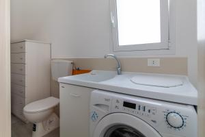 a bathroom with a washing machine and a toilet at Villa Vani - Appartamento 1 in Marina di Ragusa +21 photos