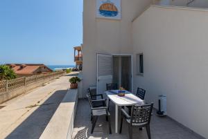 a table and chairs on the balcony of a building at Villa Vani - Appartamento 1 in Marina di Ragusa